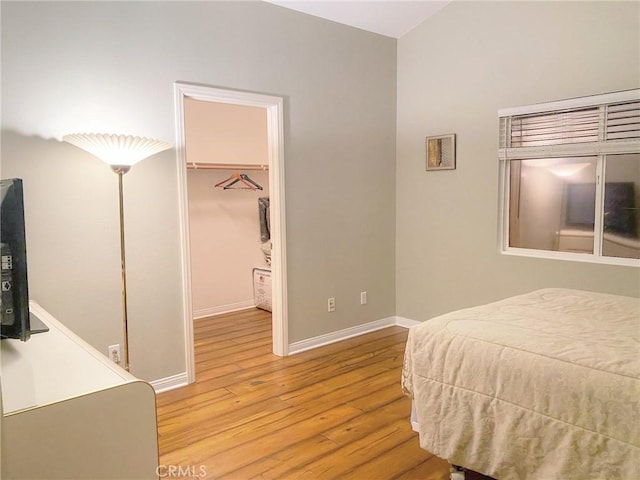 bedroom with light wood-type flooring, a spacious closet, and a closet