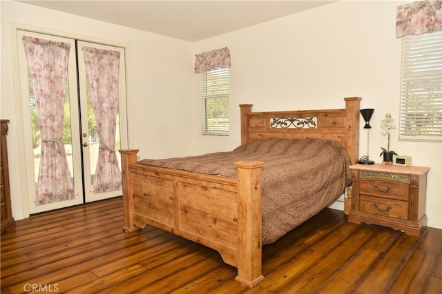 bedroom featuring dark hardwood / wood-style flooring, access to outside, and multiple windows