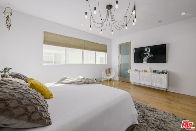 bedroom with hardwood / wood-style floors and a chandelier