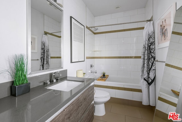 full bathroom featuring tile patterned flooring, shower / bath combination with curtain, toilet, and vanity