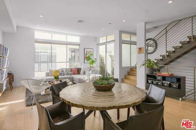 dining space featuring light wood-type flooring and expansive windows