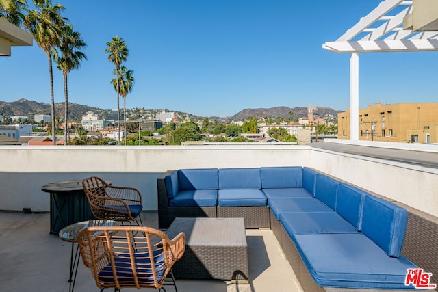 view of patio with a mountain view, a balcony, and an outdoor hangout area