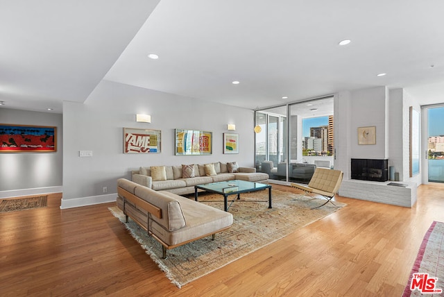 living room with wood-type flooring and a brick fireplace