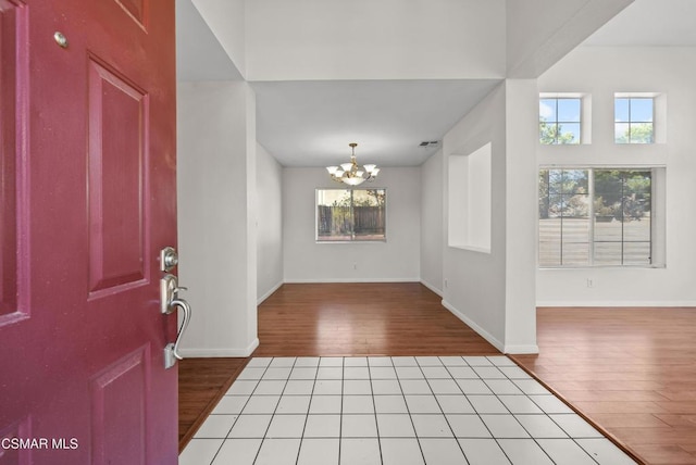 foyer with hardwood / wood-style flooring and an inviting chandelier