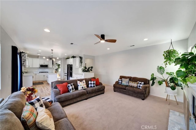 carpeted living room with ceiling fan