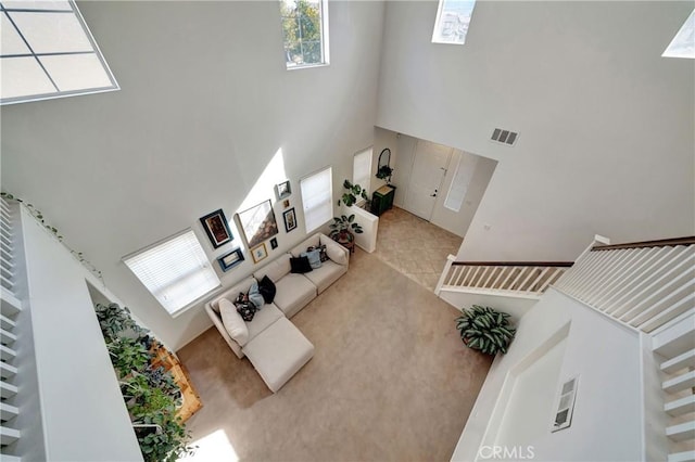 living room featuring a towering ceiling and a healthy amount of sunlight