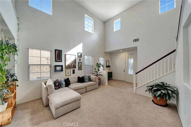 carpeted living room featuring a high ceiling