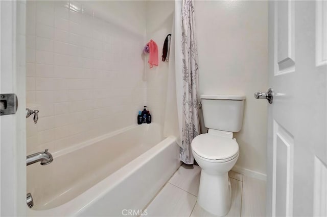 bathroom with shower / tub combo with curtain, tile patterned flooring, and toilet