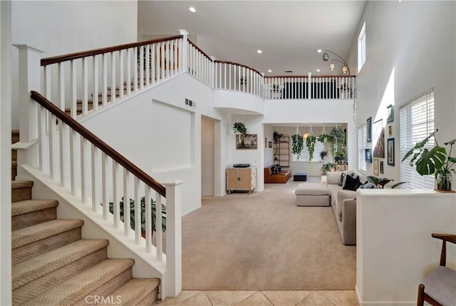 carpeted living room featuring a high ceiling