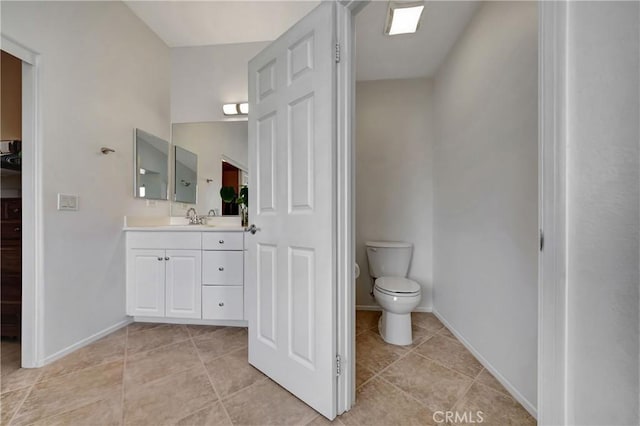 bathroom featuring tile patterned floors, vanity, and toilet