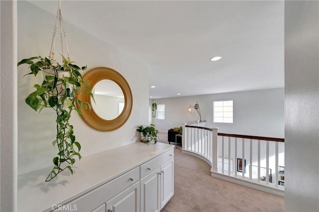 hall with light colored carpet