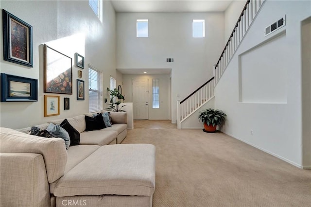 living room featuring light colored carpet and a high ceiling