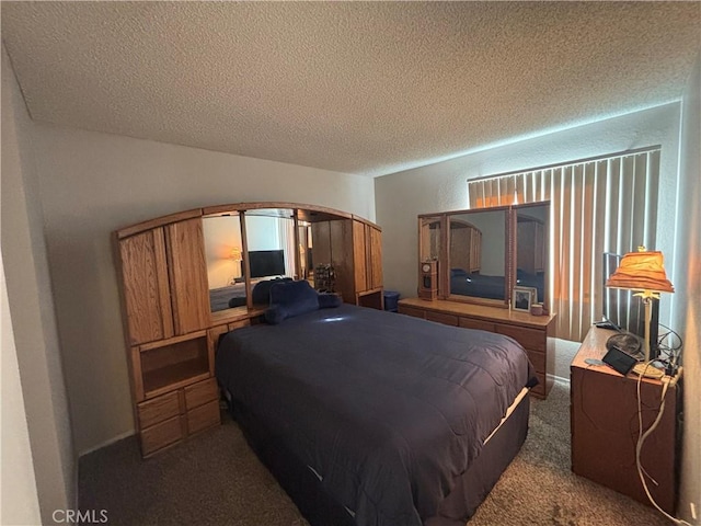 bedroom with dark colored carpet and a textured ceiling