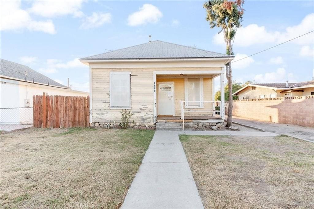 bungalow-style house featuring covered porch and a front yard