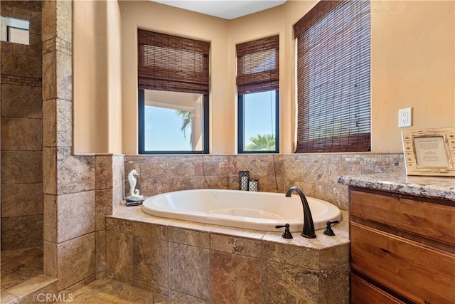 bathroom with tiled bath and vanity