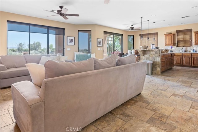 living room featuring ceiling fan and sink