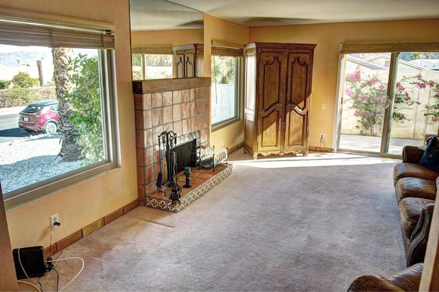 living room with a tile fireplace and carpet floors