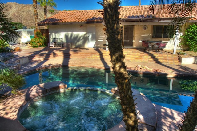 view of swimming pool with a mountain view and a patio area