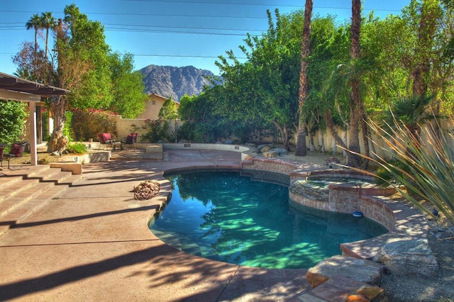 view of swimming pool featuring an in ground hot tub, a mountain view, and a patio