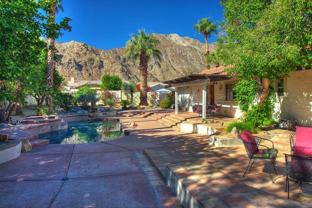 view of pool featuring a mountain view, an in ground hot tub, and a patio area