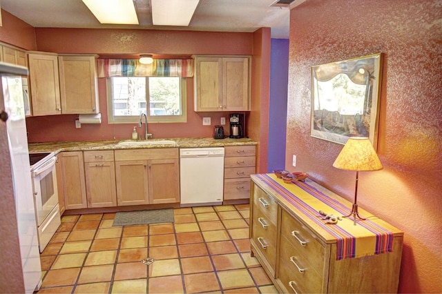 kitchen with light tile patterned floors, white appliances, light brown cabinets, and sink