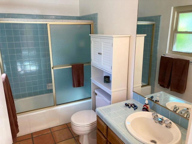 full bathroom featuring tile patterned floors, vanity, combined bath / shower with glass door, and toilet