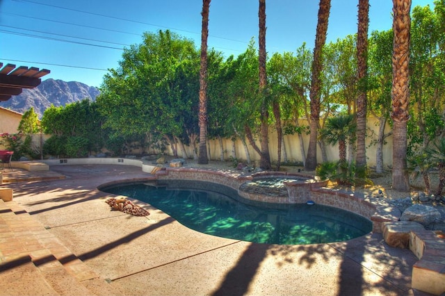 view of pool featuring a mountain view, an in ground hot tub, and a patio area