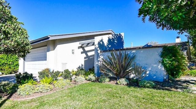 view of side of home with a lawn and a garage