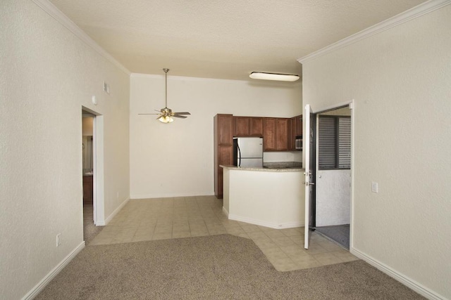 kitchen featuring light carpet, stainless steel fridge, crown molding, and a towering ceiling