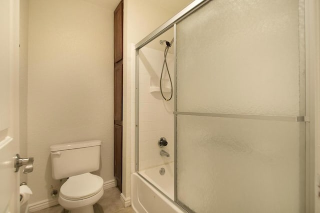 bathroom with toilet, bath / shower combo with glass door, and tile patterned floors