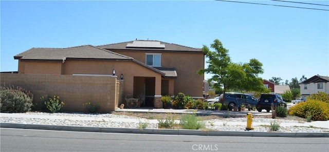 view of front of property featuring solar panels