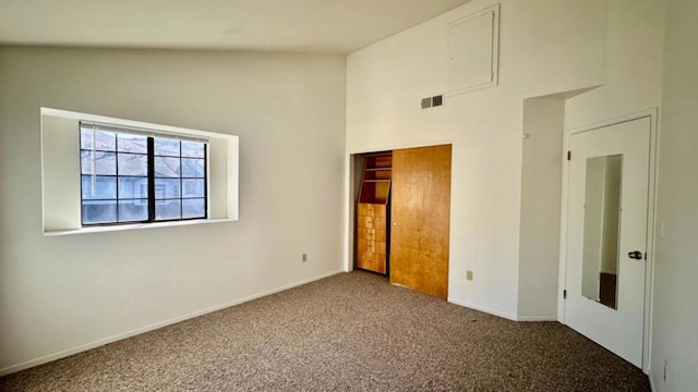 unfurnished bedroom featuring a closet, carpet, and lofted ceiling