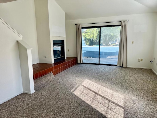 unfurnished living room with carpet flooring, lofted ceiling, and a fireplace