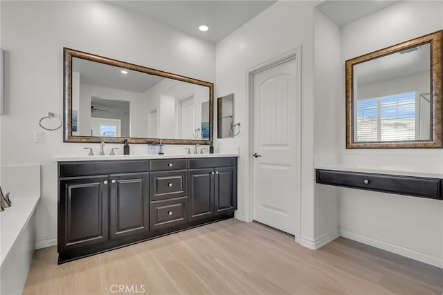 bathroom with ceiling fan, vanity, and wood-type flooring