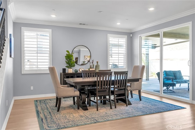 dining space featuring a wealth of natural light, light hardwood / wood-style floors, and ornamental molding