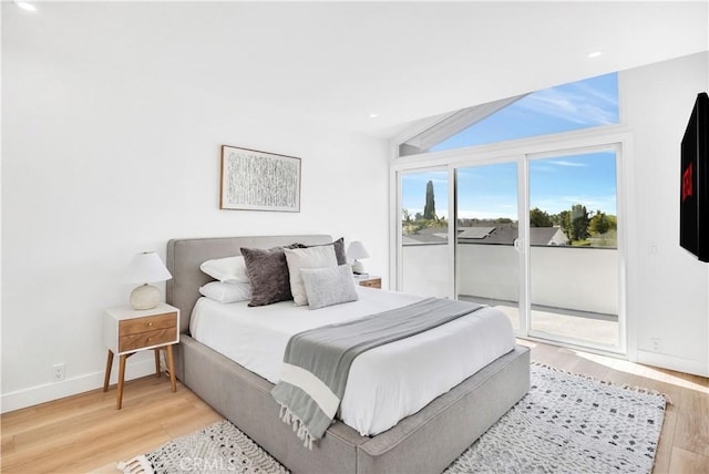 bedroom featuring light wood-type flooring, access to outside, and vaulted ceiling