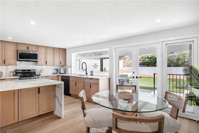 kitchen with decorative backsplash, stainless steel appliances, light hardwood / wood-style floors, and sink