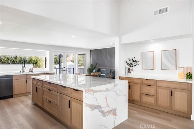 kitchen with dishwasher, a kitchen island, light hardwood / wood-style floors, and sink