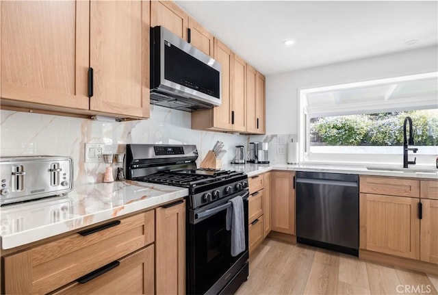 kitchen featuring light brown cabinetry, sink, stainless steel appliances, and light hardwood / wood-style floors