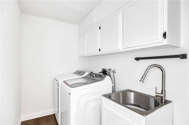 laundry room with cabinets, sink, dark wood-type flooring, and washing machine and clothes dryer