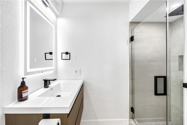 bathroom with vanity and a shower with shower door