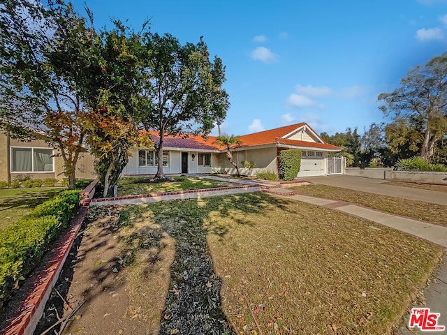 ranch-style home featuring a front lawn and a garage