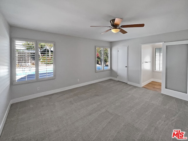 unfurnished bedroom with ceiling fan, light carpet, and multiple windows