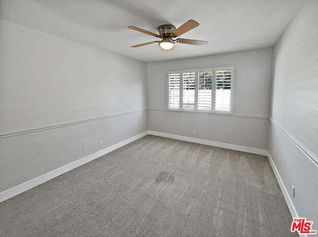 carpeted spare room featuring ceiling fan