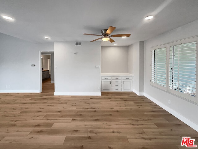 unfurnished room with ceiling fan and hardwood / wood-style flooring