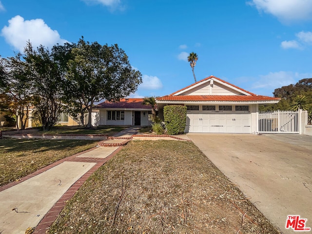 ranch-style home with a garage and a front lawn