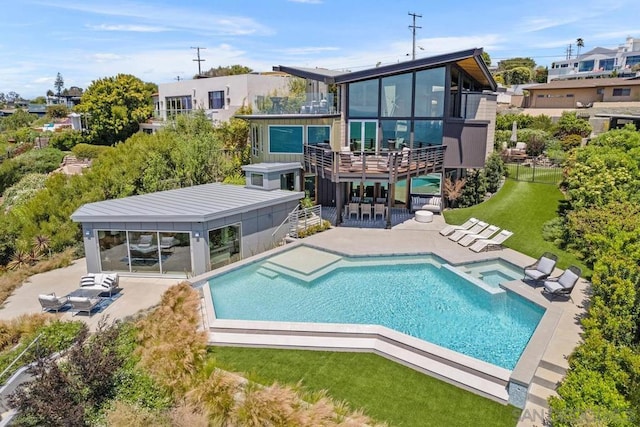 back of house with a sunroom, a pool with hot tub, a yard, and a patio