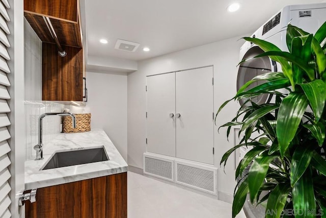 kitchen featuring light stone countertops and sink