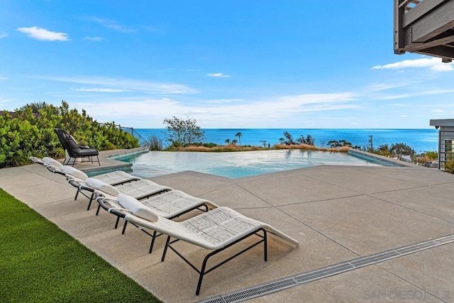 view of pool featuring a patio area and a water view