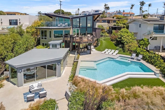 rear view of property with a pool with hot tub and a patio area